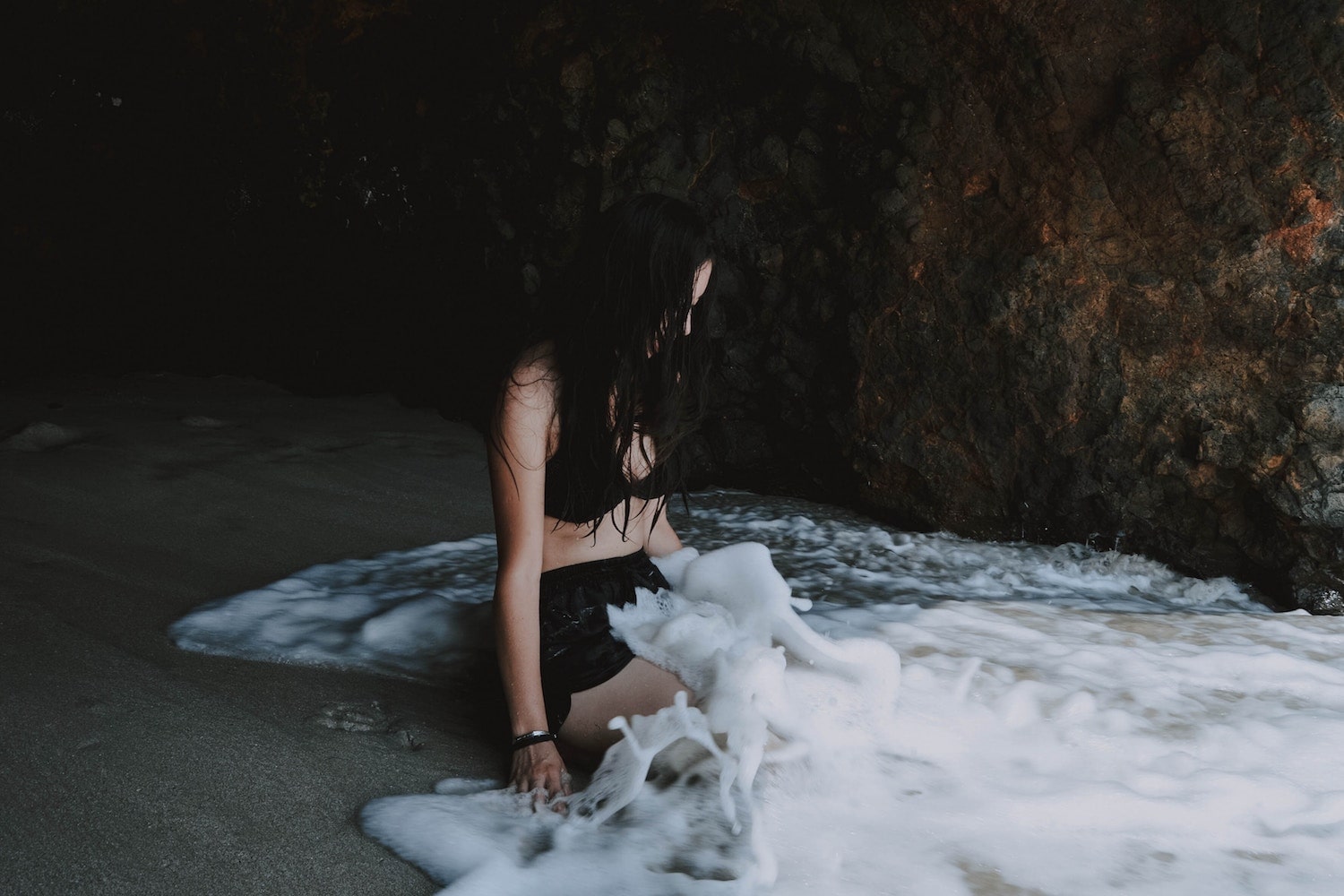 Gay Punta Mita Mexico. Girl sits in water inside a cave in Punta Mita. 